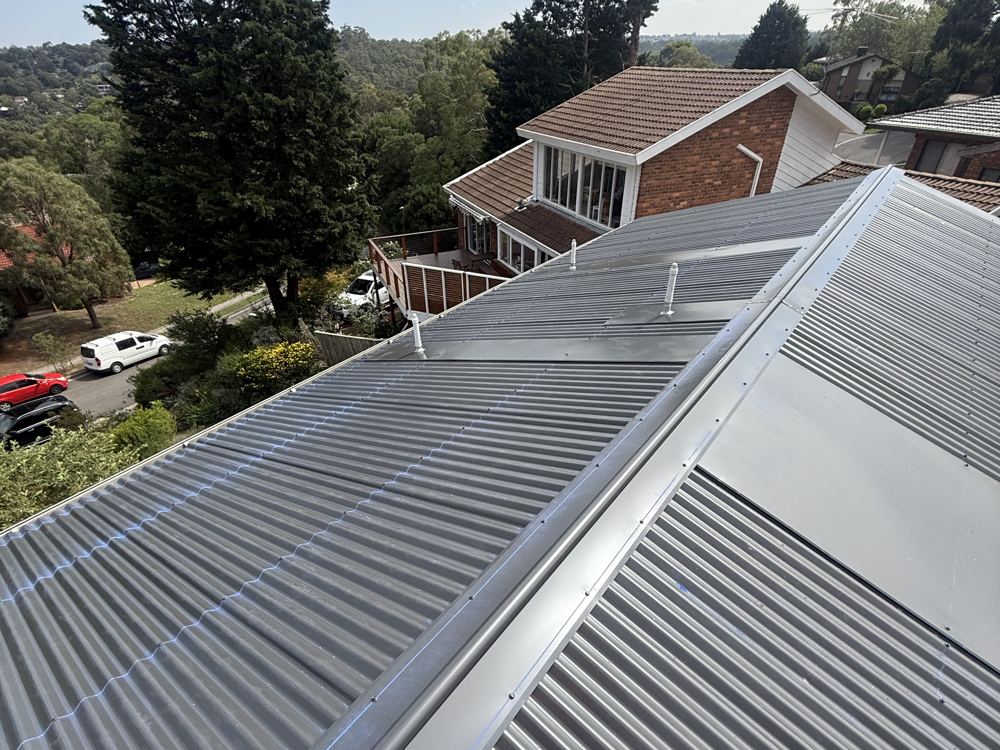 New dark corrugated Colorbond roof with ridge capping, overlooking leafy Melbourne suburbs