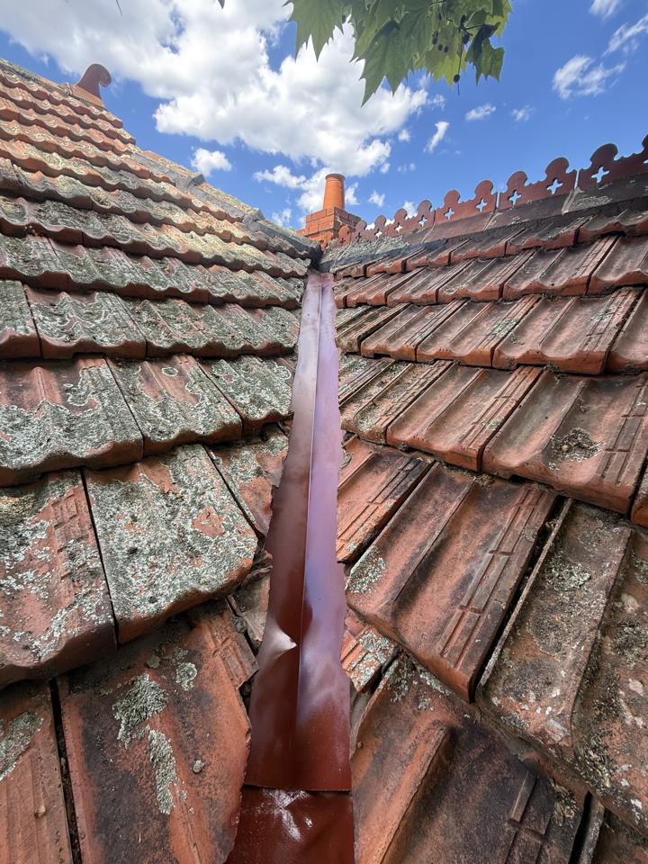 New valley flashing installed between the terracotta tiles
