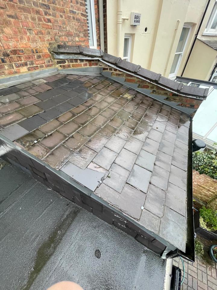 Worn slate roof with mismatched and patched slates